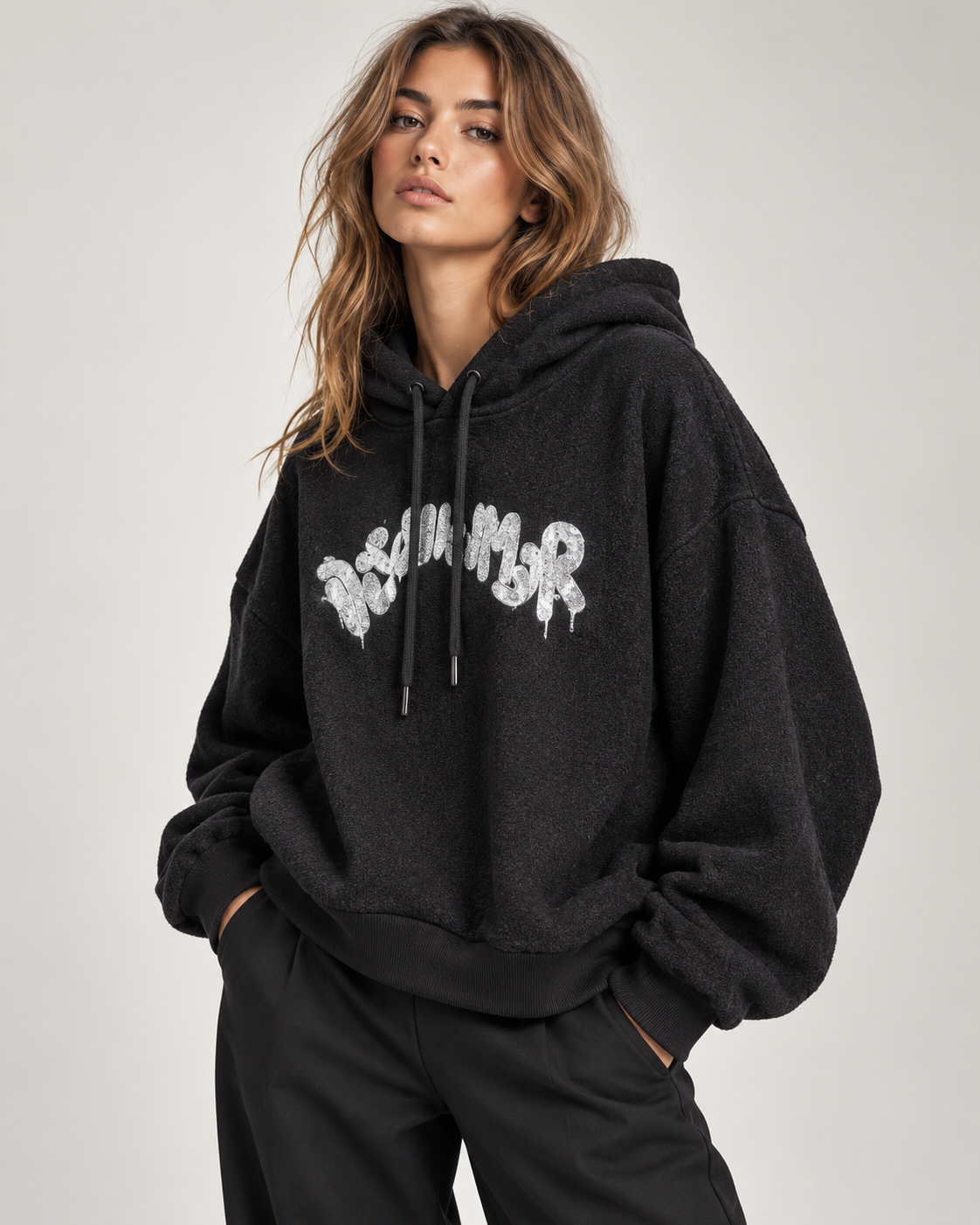 Felpa Disclaimer nera con cappuccio e logo argentato indossato da una modella